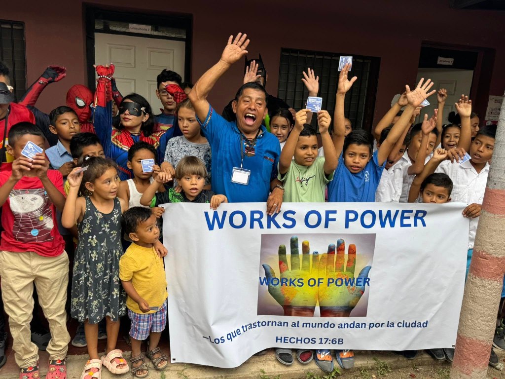 children holding the works of power banner